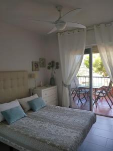 1 dormitorio con 1 cama y ventilador de techo en Luz de Tropicana en La Herradura