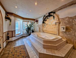 a large bathroom with a large tub in it at Berghotel Almrausch in Berwang