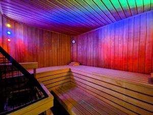 貝旺的住宿－阿爾姆勞什貝格酒店，一间拥有紫色和粉色灯光的木制桑拿浴室