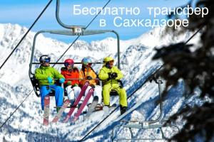 a group of people sitting on a ski lift at Orran Hotel and Resort in Solak