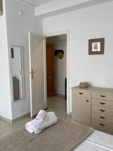 biały pokój z łóżkiem i lustrem w obiekcie RichMarHome w mieście Pego