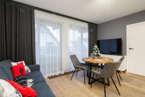 Televízia a/alebo spoločenská miestnosť v ubytovaní GórSKI Przystanek Apartament Satoła 1