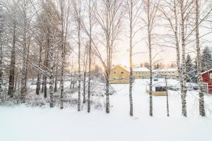 a snow covered yard with a house and trees at Kitka's Gem, luxurious condo in Kuusamo, Lapland in Kuusamo
