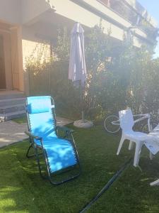 duas cadeiras e um guarda-sol num quintal em Casa Alma monolocale per 2 persone em Porto Ercole