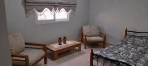 a bedroom with a bed and a chair and a table at HOUSE IN AL AIN in Al Ain