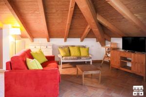 sala de estar con sofá rojo y almohadas amarillas en TORRETTA 9 by Design Studio, en Bellano