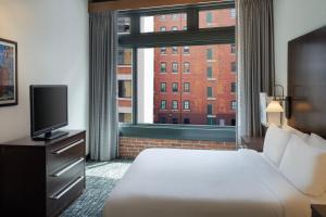 a hotel room with a bed and a large window at Residence Inn by Marriott Boston Downtown Seaport in Boston