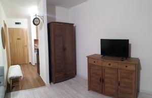 a living room with a television on a wooden dresser at Apartment B45 Borovets Gardans in Borovets
