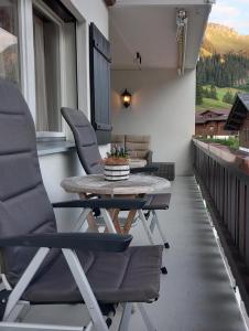 Un patio con sillas y una mesa en el balcón. en Mountain Horizon, en Schwarzsee