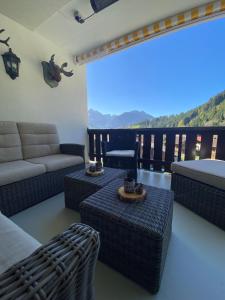 a living room with a couch and tables and a view at Mountain Horizon in Schwarzsee +8 photos