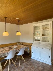 a dining room with a table and two white chairs at Mountain Horizon in Schwarzsee