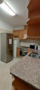 a kitchen with a sink and a stainless steel refrigerator at Recanto do Algarve in Olhão