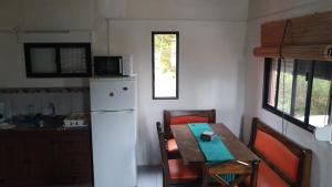 a kitchen with a table and a white refrigerator at Novgorod in Aguas Dulces