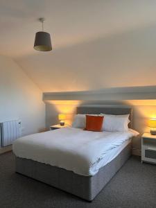 a bedroom with a large bed with two lamps at Dunmore East Holiday and Golf Resort Apartments in Dunmore East