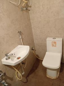 a bathroom with a white toilet and a sink at HOTEL NEW MN GRAND in Hyderabad