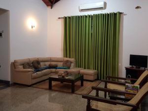 マハラガマにあるMaharagama 5BR bungalow 1BR USD 21 per nightのリビングルーム(ソファ、緑のカーテン付)