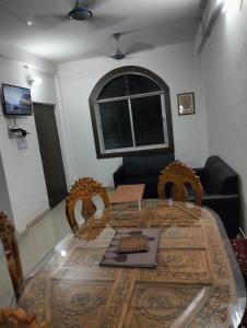 a dining room table with chairs and a couch at Darbar Villa in Bodh Gaya
