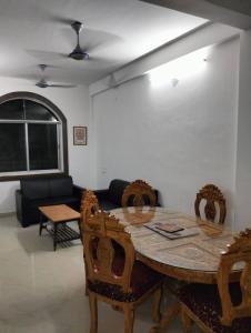 a dining room with a table and chairs and a couch at Darbar Villa in Bodh Gaya