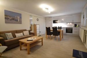 a living room with a couch and a table at Haus Königshöhe in Grömitz