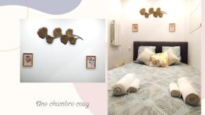 1 dormitorio con 1 cama con toallas y mariposas en la pared en Le Petit Suc du Puy En Velay , Hyper centre ,calme ,Parking proche en Le Puy-en-Velay