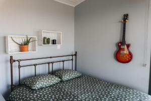 a bedroom with a bed with a guitar on the wall at Zima Edge in Parekklisha