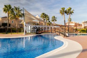a resort swimming pool with a bridge and palm trees at Bajo # Chill-out # Playa a 8min # Netflix in Vera