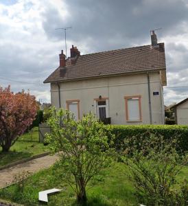 uma casa branca com uma árvore em frente em Chambre em Montceau-les-Mines