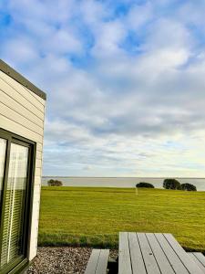 鄧莫爾東的住宿－Dunmore East Ocean View Suite，享有田野和海洋景色的建筑