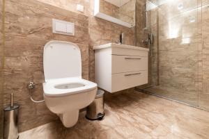 a bathroom with a white toilet and a shower at Emery Apartments in Pristina +38 photos