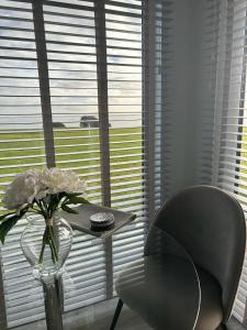 una mesa con un jarrón de flores y una silla en Dunmore East Ocean View Suite en Dunmore East