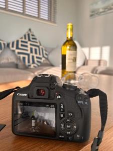 kamera siedząca na stole z butelką wina w obiekcie Dunmore East Ocean View Suite w mieście Dunmore East