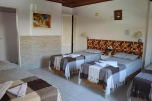 a hotel room with two beds in a room at Break House Beach in Florianópolis