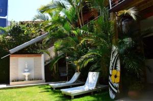 a group of chairs sitting next to a palm tree at Break House Beach in Florianópolis