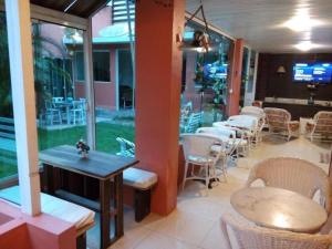 a restaurant with tables and chairs in a room at Break House Beach in Florianópolis