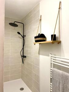 une douche dans une salle de bain avec du carrelage blanc dans l'établissement L'Art appart' - T2 - Lit King Size - Proche centre, à Amiens 33 autres photos