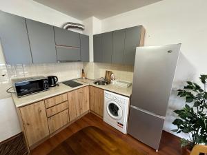 a kitchen with a refrigerator and a washing machine at Gramadeto two bedroom apartment next to Gondola in Bansko