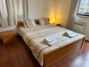 a bedroom with a large bed with two towels on it at Gramadeto two bedroom apartment next to Gondola in Bansko