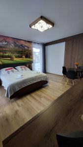 una camera con un grande letto e uno schermo per proiezione di CIABAS Apartamenty a Białka