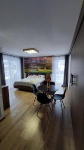 1 dormitorio con 1 cama, mesa y sillas en CIABAS Apartamenty, en Białka Tatrzanska