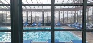 - une piscine avec des chaises bleues dans un bâtiment dans l'établissement Nulle part ailleurs, à Trouville-sur-Mer