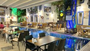 een zwembad in het midden van een restaurant met tafels en stoelen bij Istankoy Hotel in Bodrum City