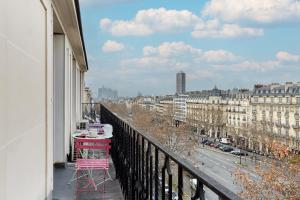 a balcony with a pink table and a view of a city at Apartment Arc de Triomphe by Studio prestige in Paris