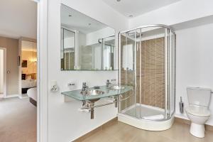 a bathroom with two sinks and a shower and a toilet at Apartment Arc de Triomphe by Studio prestige in Paris +23 photos
