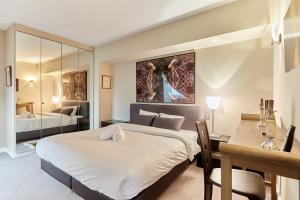 a bedroom with a large bed and a desk with a desk at Apartment Arc de Triomphe by Studio prestige in Paris