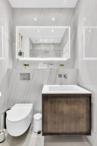 a white bathroom with a toilet and a sink at Luxury 3 bedroom apartment in the heart of High Street Kensington, London. in London