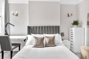 um quarto com uma cama, uma secretária e uma cadeira em Luxury 3 bedroom apartment in the heart of High Street Kensington, London. em Londres