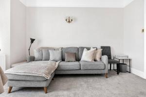 a living room with a gray couch and a chair at Luxury 3 bedroom apartment in the heart of High Street Kensington, London. in London