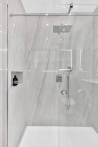 a bathroom with a shower with a glass door at Luxury 3 bedroom apartment in the heart of High Street Kensington, London. in London