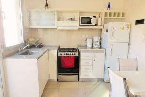 a small kitchen with a stove and a refrigerator at Cambacuá La Rural in Buenos Aires