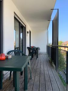 eine Terrasse mit 2 Tischen und Stühlen auf dem Balkon in der Unterkunft Apartments/Wohnungen direkt in Aschaffenburg in Aschaffenburg